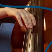 Main de musicien jouant de la contrebasse.