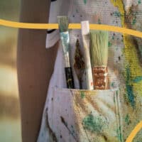 Des pinceaux de peintures dans une poche.