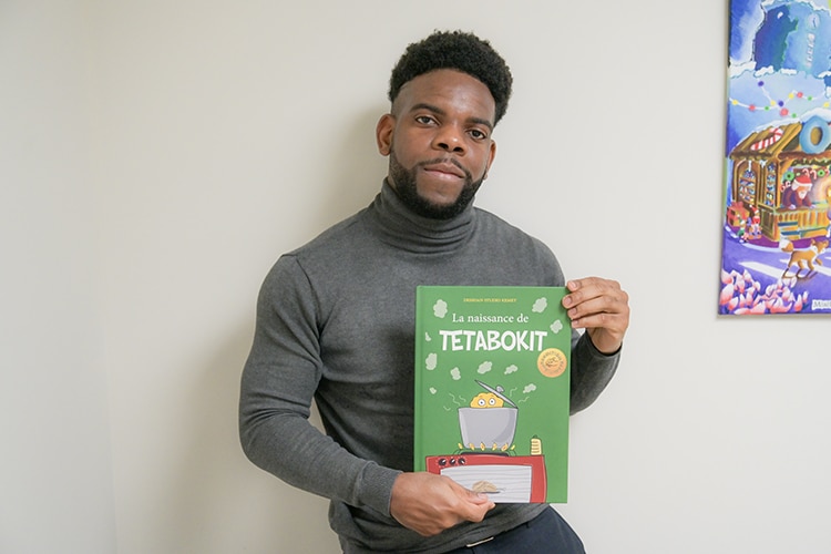 Danick Lator, aka Dessdan, tient dans ses mains un exemplaire de Tetabokit.