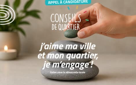 Main féminine posant un galet vert sur trois galets gris empilés.